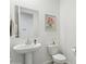 A powder room features a pedestal sink, a toilet, a framed mirror, and tile floors at 5046 W Karl St, San Tan Valley, AZ 85144