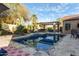 Backyard featuring a pool with safety net, desert landscaping, outdoor kitchen with pergola, and patio at 5215 S Monte Vista St, Chandler, AZ 85249
