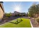 Sunny backyard with artificial grass, drought-tolerant landscaping, and a garden bed feature at 5215 S Monte Vista St, Chandler, AZ 85249