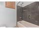 Bathroom features a bathtub with a shower and sleek gray stone tiling at 5215 S Monte Vista St, Chandler, AZ 85249