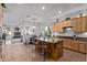Open kitchen with wood cabinets, granite countertops, and an island with seating, flowing into a dining area at 5215 S Monte Vista St, Chandler, AZ 85249