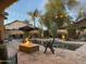 Evening view of a backyard pool with a fire pit,desert landscaping, and cozy patio lighting at 5215 S Monte Vista St, Chandler, AZ 85249