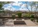 Relaxing backyard showcasing a brick patio, fire pit, gravel landscaping, and perimeter fence at 5723 E Jake Hvn, Cave Creek, AZ 85331