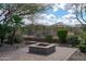 Brick patio area with desert landscaping, a modern stone fire pit, and perimeter fence at 5723 E Jake Hvn, Cave Creek, AZ 85331