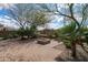 Well-manicured backyard with a brick patio, fire pit, and lush desert landscaping at 5723 E Jake Hvn, Cave Creek, AZ 85331
