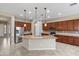 Open kitchen with stainless steel appliances, large island, and stylish pendant lighting at 5723 E Jake Hvn, Cave Creek, AZ 85331