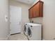 Convenient laundry room including a washer, dryer, and overhead cabinets for storage at 5723 E Jake Hvn, Cave Creek, AZ 85331