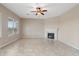 Spacious living room with a ceiling fan, fireplace and tile flooring, creating a warm and inviting atmosphere at 5723 E Jake Hvn, Cave Creek, AZ 85331
