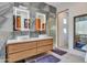 Light and airy bathroom featuring double sinks, illuminated mirrors and large format tile at 5805 E Agave Pl, Carefree, AZ 85377