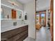 Modern bathroom with an illuminated mirror, wood vanity, and a view to the patio at 5805 E Agave Pl, Carefree, AZ 85377