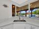 Bright kitchen sink with white marble countertop offers views of backyard pool and patio at 5805 E Agave Pl, Carefree, AZ 85377