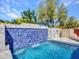 Gorgeous pool with a tile waterfall feature and surrounding patio space at 5805 E Agave Pl, Carefree, AZ 85377