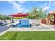 Inviting pool area with a red umbrella, lounge chairs, and manicured lawn at 5805 E Agave Pl, Carefree, AZ 85377