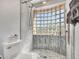 Bathroom shower featuring glass block window, tiled walls, and a pebble floor at 5805 E Agave Pl, Carefree, AZ 85377