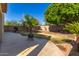 Backyard featuring desert landscaping, a concrete patio, mature trees, and block wall fencing at 6312 W Villa Linda Dr, Glendale, AZ 85310