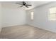 A bright bedroom shows wood-look floors, a ceiling fan, natural light, and a neutral color palette at 6312 W Villa Linda Dr, Glendale, AZ 85310