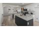Bright kitchen features white cabinets, stainless steel appliances, a large island and wood-look flooring at 6312 W Villa Linda Dr, Glendale, AZ 85310