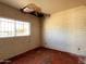 Bedroom needing renovation, featuring brick walls, and a window with barred security at 6408 S 10Th St, Phoenix, AZ 85042