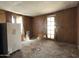 Room featuring wood paneling, a refrigerator and an exterior door in need of repair at 6408 S 10Th St, Phoenix, AZ 85042