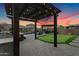 Relaxing backyard featuring a pergola with lights, lounge chairs, putting green, a pool, and hot tub at 7694 S Reseda St, Gilbert, AZ 85298