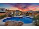 Backyard oasis featuring a pool, spa, and outdoor seating areas with string lights at dusk at 7694 S Reseda St, Gilbert, AZ 85298