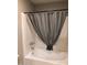 Bathroom featuring a white bathtub with silver hardware and gray shower curtain at 839 S Westwood -- # 187, Mesa, AZ 85210
