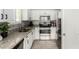 Bright kitchen boasts white cabinets, granite countertops, stainless steel appliances, and modern tile flooring at 8541 W Echo Ln, Peoria, AZ 85345