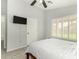 Spacious bedroom with wood-look tile flooring, neutral walls, shuttered windows, and modern ceiling fan at 8541 W Echo Ln, Peoria, AZ 85345