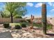 Lush backyard with artificial grass putting green, desert landscaping, and mature trees at 8960 W Kerry Ln, Peoria, AZ 85382