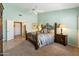 A bright and airy bedroom with a ceiling fan, and french doors, includes carpet flooring, and light green walls at 8960 W Kerry Ln, Peoria, AZ 85382