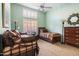 A carpeted bedroom with twin beds, ceiling fan, and window shutters features neutral-colored walls at 8960 W Kerry Ln, Peoria, AZ 85382