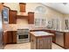 A kitchen with a range, hood, island, cabinets, tile floors, and large windows is well lit and spacious at 8960 W Kerry Ln, Peoria, AZ 85382