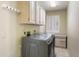 Well-lit laundry room with cabinetry, hanging rack and stainless steel washer and dryer at 8960 W Kerry Ln, Peoria, AZ 85382