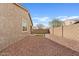 Desert landscaped backyard with view of the house and greenery in background at 9910 E Theia Dr, Mesa, AZ 85212