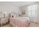 Bright bedroom featuring a comfortable bed, chandelier, and a sun-lit window at 9910 E Theia Dr, Mesa, AZ 85212