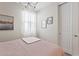 Well-lit bedroom features neutral walls, plush carpeting and a cozy quilted pink bed at 9910 E Theia Dr, Mesa, AZ 85212