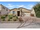 Charming single-story home featuring a well-manicured front yard with mature landscaping and a two-car garage at 9910 E Theia Dr, Mesa, AZ 85212