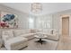 A sunlit living room with a comfortable sectional sofa, decorative pillows, and a chic round coffee table at 9910 E Theia Dr, Mesa, AZ 85212