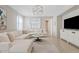 A bright living room features a large sectional sofa, stylish decor, and seamlessly connects to the dining area at 9910 E Theia Dr, Mesa, AZ 85212
