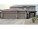 Two-story home with three-car garage, neutral stucco, stone accents, and covered front porch at 114 N 119Th Dr, Avondale, AZ 85323