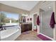 Bathroom featuring a tub with a view, walk-in shower, and double sink vanity at 1240 E Friess Dr, Phoenix, AZ 85022