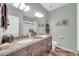 Bathroom with dual sinks, granite counters, wood cabinets, and a framed mirror at 1240 E Friess Dr, Phoenix, AZ 85022