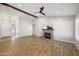 Spacious living room with wood-look floors, vaulted ceilings, ceiling fan, and a decorative fireplace at 1244 E Princeton Ave, Gilbert, AZ 85234