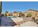 Inviting backyard with a pool featuring a rock waterfall, desert landscaping, and a spacious patio area at 12814 W Windrose Dr, El Mirage, AZ 85335