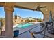 Relaxing view from a covered patio overlooking a pool with a rock waterfall and well-maintained landscaping at 12814 W Windrose Dr, El Mirage, AZ 85335