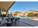 Backyard view showcasing a pool with rock waterfall, covered patio with seating, and desert landscaping at 12814 W Windrose Dr, El Mirage, AZ 85335