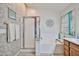 Bright bathroom featuring a soaking tub, glass shower, and stylish decor against a textured wall at 12814 W Windrose Dr, El Mirage, AZ 85335