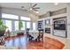 Cozy dining area featuring hardwood floors, vaulted ceiling, a fireplace, large windows, and a cozy table setting at 12814 W Windrose Dr, El Mirage, AZ 85335