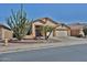 Inviting single-story home featuring a three-car garage and desert landscaping with a mature cactus and palm trees at 12814 W Windrose Dr, El Mirage, AZ 85335