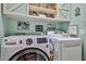 Well-organized laundry room with modern washer and dryer, built-in shelving, and charming decorative accents at 12814 W Windrose Dr, El Mirage, AZ 85335